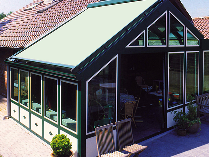 green conservatory awning over top a sun room of a restuaurant
